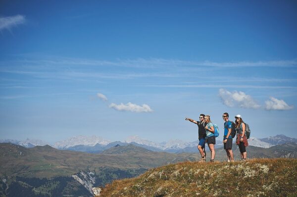 Ein Berggipfel mit Blick über die Graubünden Berge. Eine Gruppe Wanderer welche in die Ferne blickt in der Nähe von Arosa